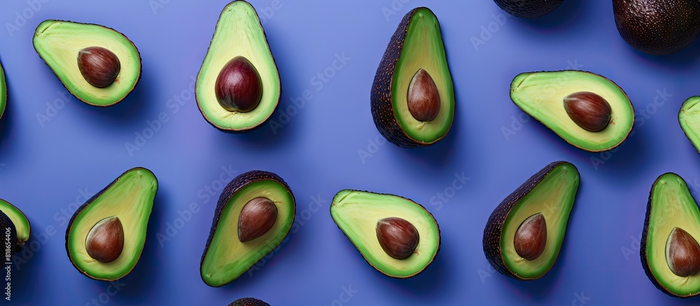 Poster Avocado halves arranged in a pattern on a bright blue violet pastel background creating a banner like copy space image