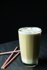 Glass of latte coffee and drinking straws on grey background 
