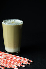 Latte coffee and drinking straws on black background