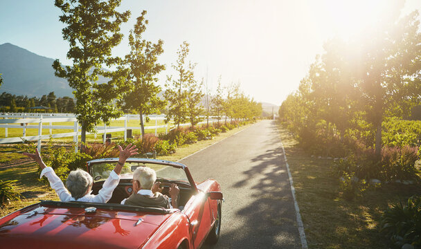 Couple, convertible and hands up for road trip celebration or travel journey in California, transportation or vacation. Old people, retirement and morning adventure or vineyard, drive or countryside
