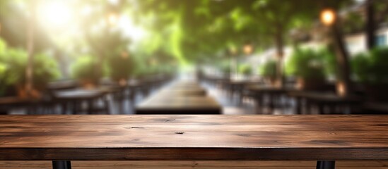 Fototapeta premium Clean and bright light foreground of a wood table with a blur coffee shop background This copy space image is perfect for displaying products through montage