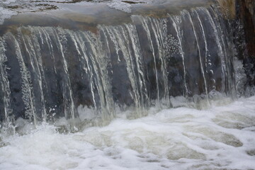 Small waterfall with white foam at bottom 