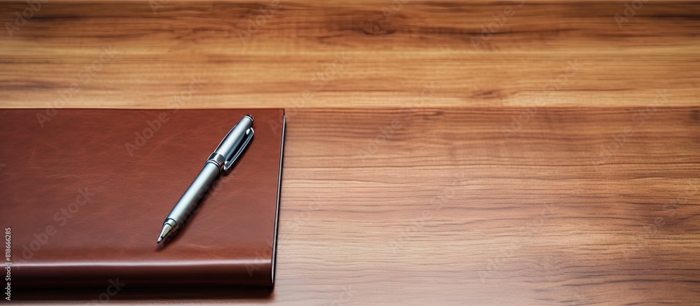Poster closeup of a personal organizer with a pen on a wooden table providing ample copy space for an image