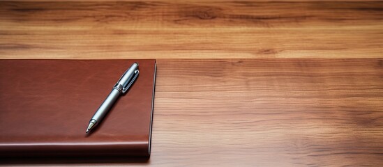 Closeup of a personal organizer with a pen on a wooden table providing ample copy space for an image