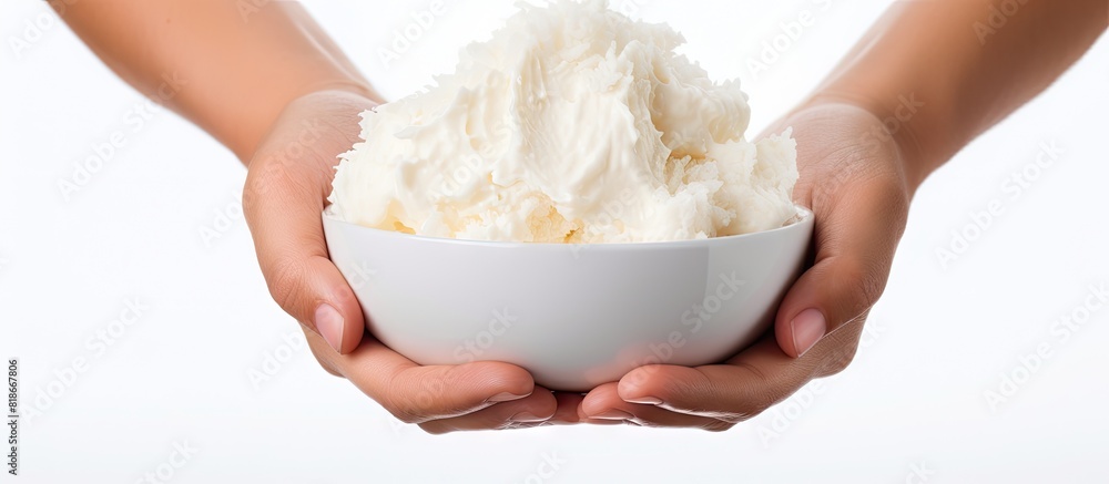 Leinwandbilder a delicious bowl of coconut ice cream is seen on a white background with female hands holding it. wi