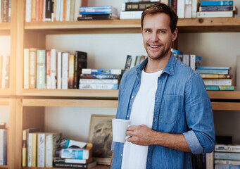 Portrait, home office and man with coffee, bookshelf and researcher with project, white mug and smile. Face, happy person and reader in study, morning tea and espresso in cup, cappuccino and relax