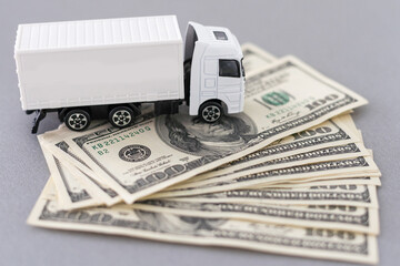 White toy truck lie on dollars, space for text.