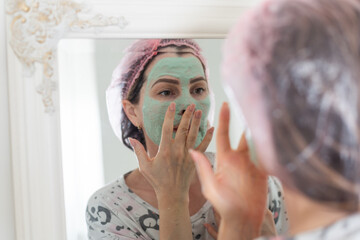 Self care: a woman applying clay mask to her face