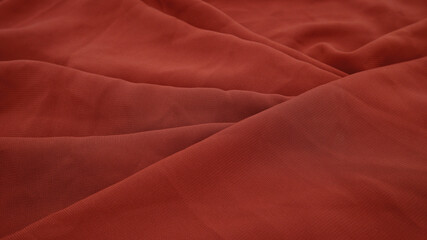 Brown fabric background with the concept of fibers and textiles, fabric texture, clothing, and texture background. The background of dark brown textiles was folded. Close-up brown fabric texture.