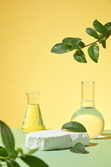 Yellow background photography with frontal shot, blank plaster pedestal with a few green tea leaves...
