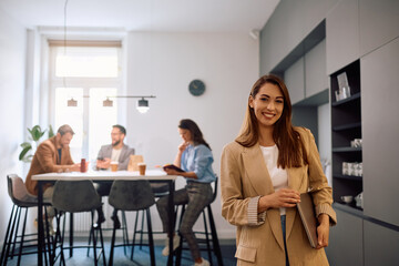 Young happy businesswoman at casual office looking at camera.