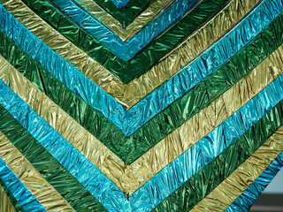 Texture or background of different green and yellow stripes of crumpled foil
