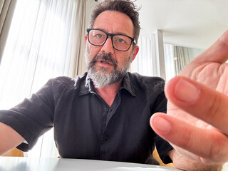 web camera view of adult man explaining online gesturing with bored expression. Businessman working...
