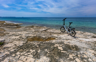 Fototapeta premium A small foldable electric tourist bike, exploring the coast by bike, bicycle tourism in Croatia