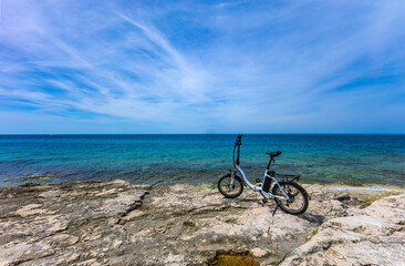 Fototapeta premium A small foldable electric tourist bike, exploring the coast by bike, bicycle tourism in Croatia