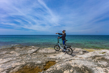 Discharged battery in an electric bike, a woman in a helmet is looking for an electric bike charger in Croatia