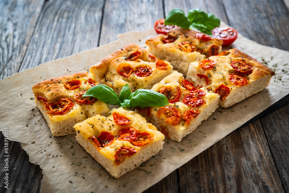 Wall mural focaccia - baked sandwich with tomatoes and basil leaves on wooden table - Wall murals