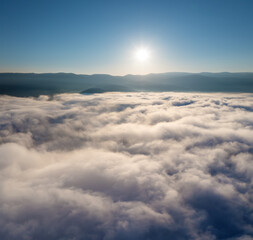 Aerial view on white clouds in mountain valley.