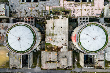 Aerial view from drone of abandoned and ruined Nuclear Power Plant or station, round tower of...