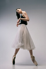 a ballerina in a bodysuit and a white skirt improvises classical and modern choreography in a photo...