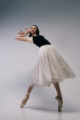 ballerina in a bodysuit and a white skirt improvises classical and modern choreography in a photo...