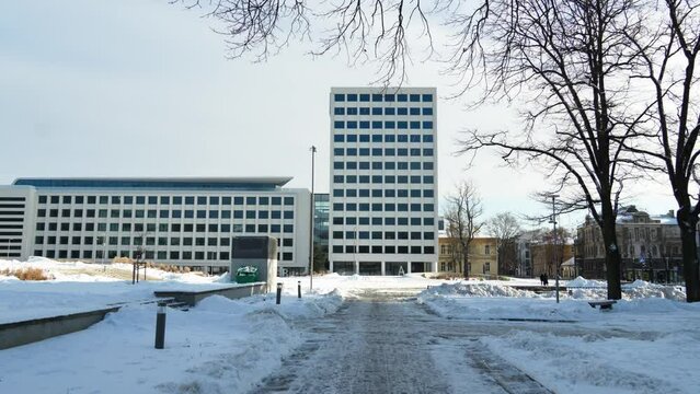 Snow-covered trail in Unity Square with urban buildings in the background in Kaunas, Lithuania