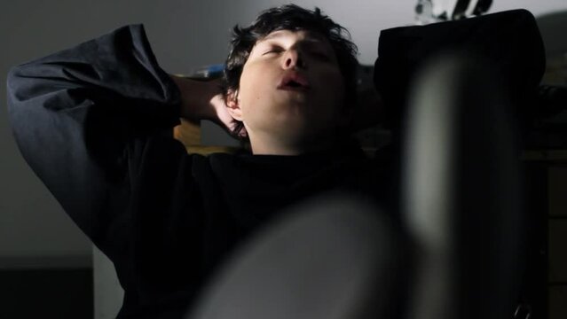 Young Caucasian man laying his feet on the desk careless while whistling. playing a role in a movie