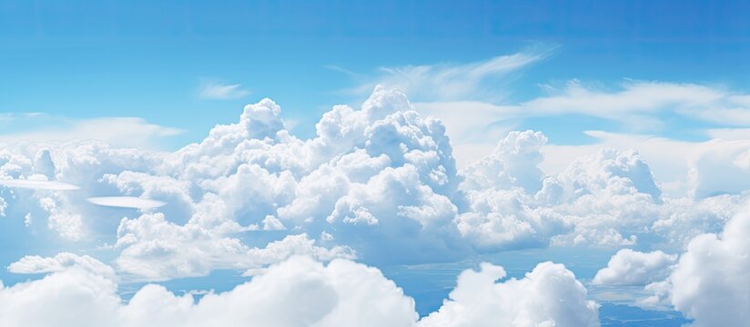 In the summer sky large white fluffy clouds float amidst a backdrop of clear brilliant blue Copy space image