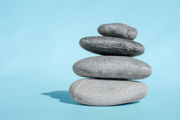 stacked smooth pebbles on blue background