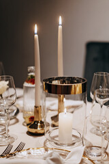 Dinner table adorned with lit candles and elegant glassware