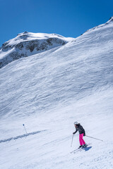 a skier in pink pants going down a snow covered mountain slope