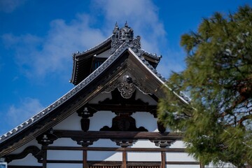 Snow-covered roof of a japanese temple under clear blue sky in a wintry landscape