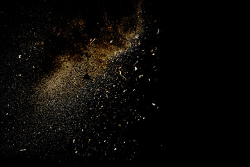 Yellow sand fly wave in the air. Golden sand explosion isolated on black background. Abstract sand cloud. Golden colored sand splash against dark background.
