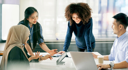 Happy businesspeople  collaborating on a new project in an office. Group of diverse businesspeople...