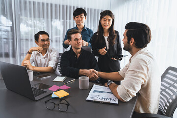 Diverse group of office employee worker shake hand after making agreement on strategic business...