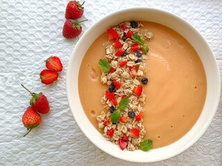 Berry smoothie bowl made from blueberry, blackberry and banana and yogurt, topped with seeds and almond, goji berry and shredded lemon skin	