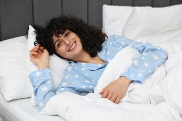 Beautiful young woman in stylish pyjama in bed at home