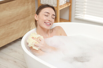 Woman taking bath with shower gel in bathroom