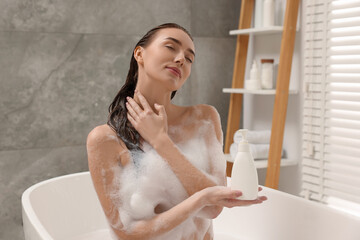 Woman taking bath with shower gel in bathroom