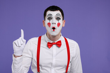 Funny mime artist gesturing on purple background