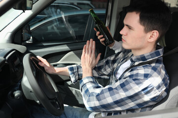 Driver refusing from alcohol while woman suggesting him beer in car, closeup. Don't drink and drive...