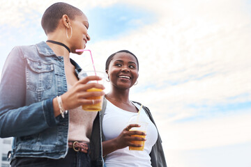 Women, together and walking with blue sky and drinks for wellness, outdoor with happiness for...