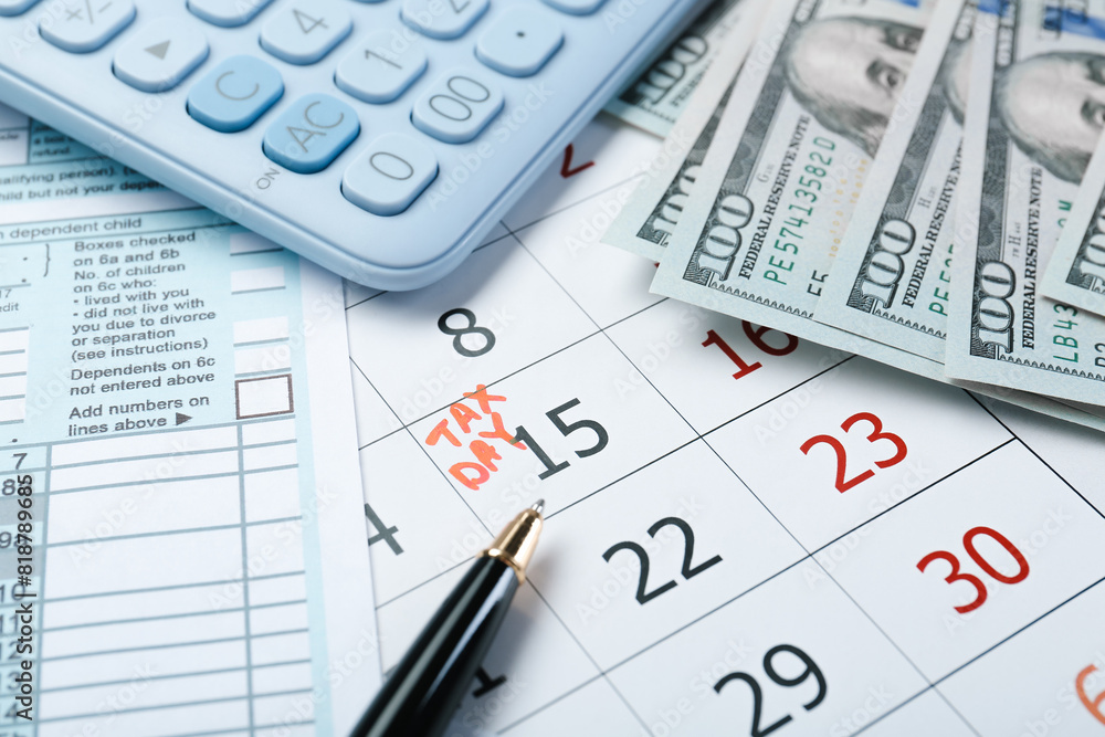 Wall mural calendar with date reminder about tax day, documents, money, pen and calculator, closeup