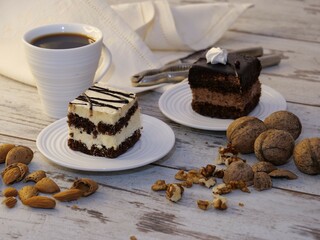Closeup of two pieces of cakes with a cup of coffee on a wooden table
