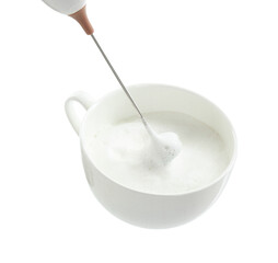Whisking milk in cup with mini mixer (frother wand) isolated on white, closeup
