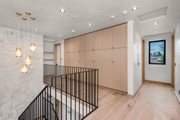 stairs and railings in a contemporary home hallway with light wood floors