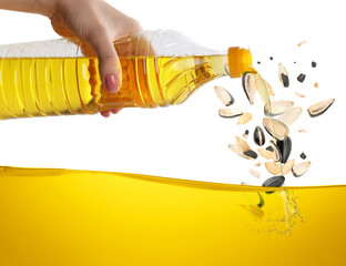Woman pouring sunflower oil on white background. Seeds falling into cooking oil