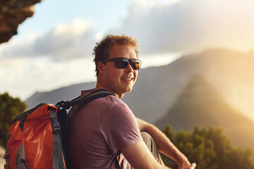 Hiking, portrait and man on mountains with travel, adventure and explore nature for holiday or eco...