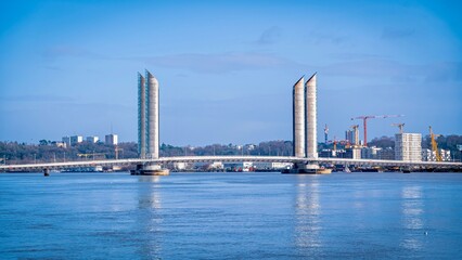 Fototapeta premium Vast expanse of water meets a cityscape of towering buildings on the distant horizon