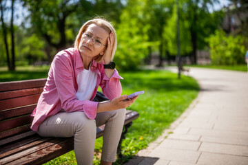 Portrait of mature woman in park. She is worried.